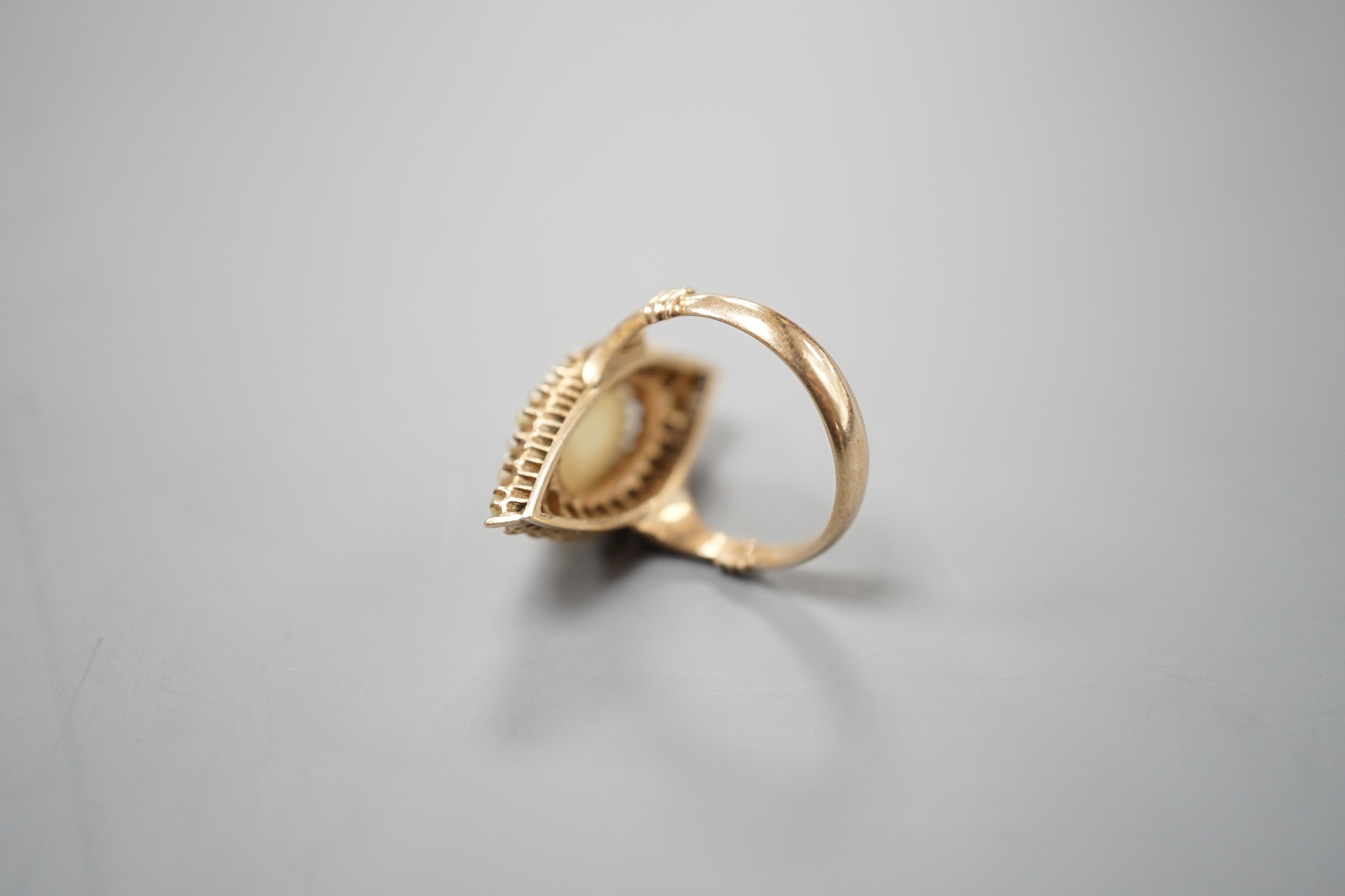A yellow meat, white opal and seed pearl set marquise shaped cluster ring, size J/K, gross weight 5.6 grams.